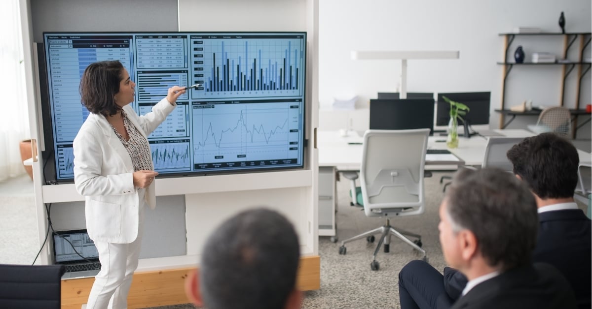 woman presenting charts at a company meeting